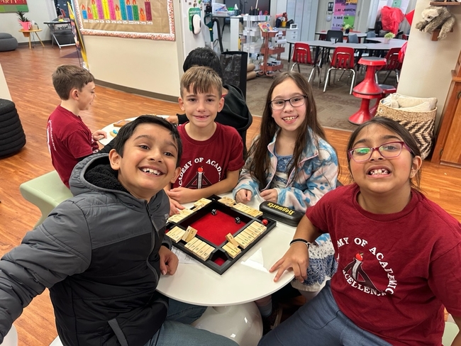 Upper elementary students playing a table game together
